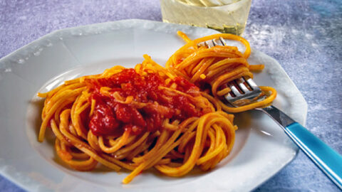 Insalata di tagliatelle al sugo di pomodoro. la pasta all'uovo da servire fredda